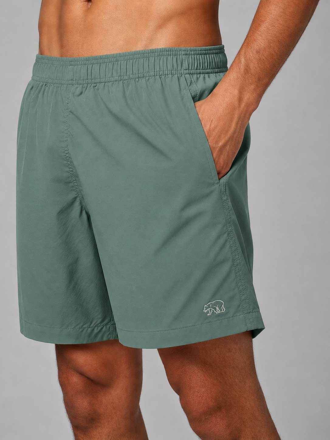 Detalhe de short de tactel verde água Bransk com cós elástico e urso bordado